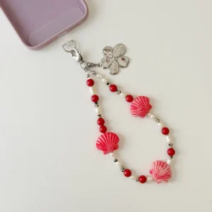 Handcrafted Coral Seashell phone wristlet strap layout with pearls and red coral beads