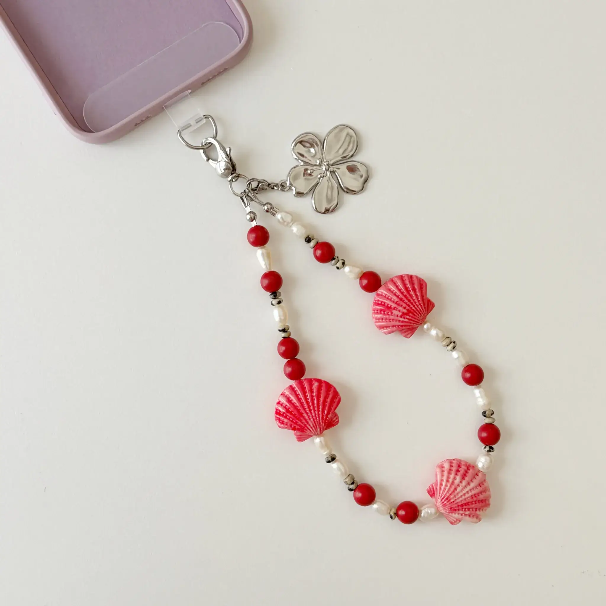 Handcrafted Coral Seashell phone wristlet strap layout with pearls and red coral beads
