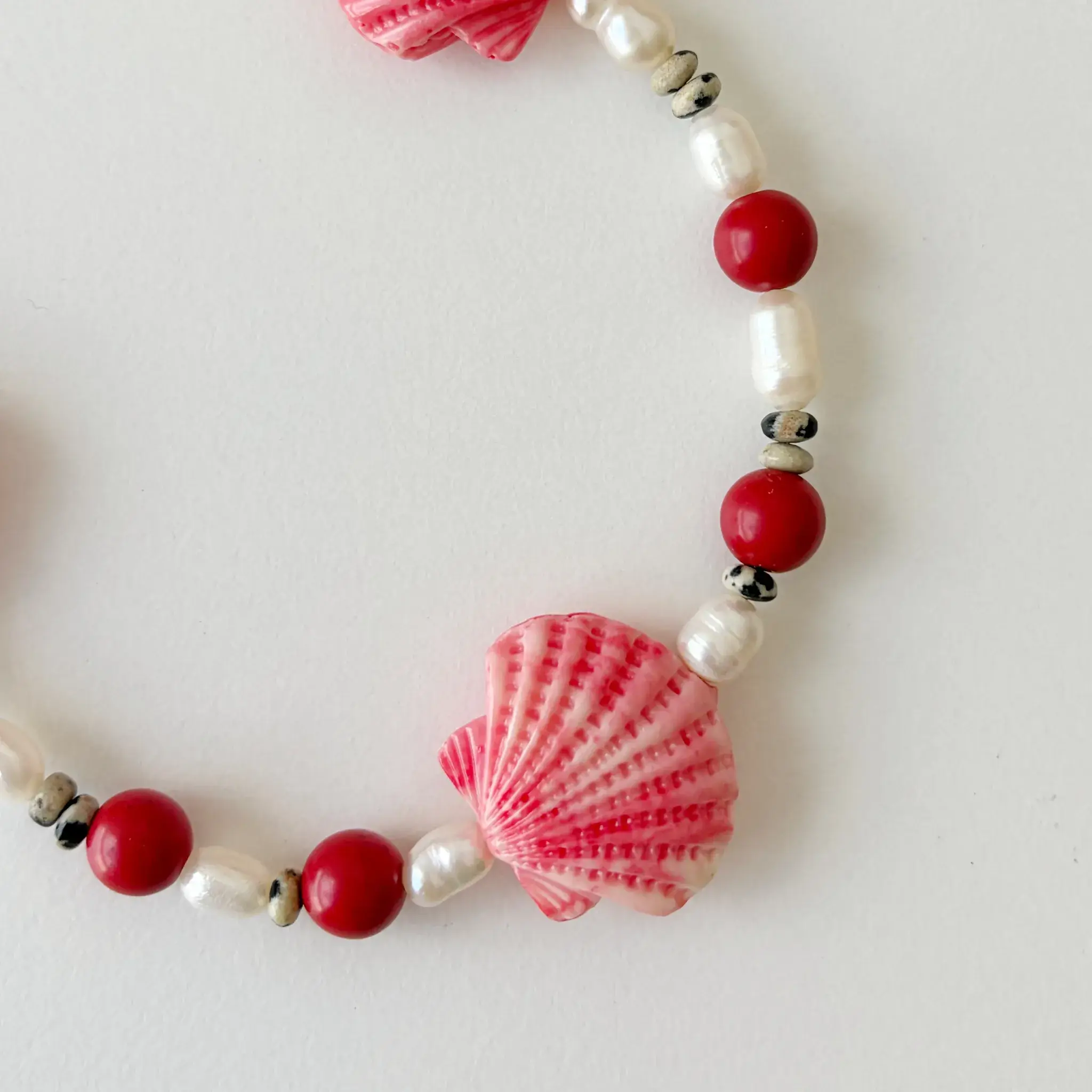 Close up of pink seashell accent and freshwater pearls on phone wristlet