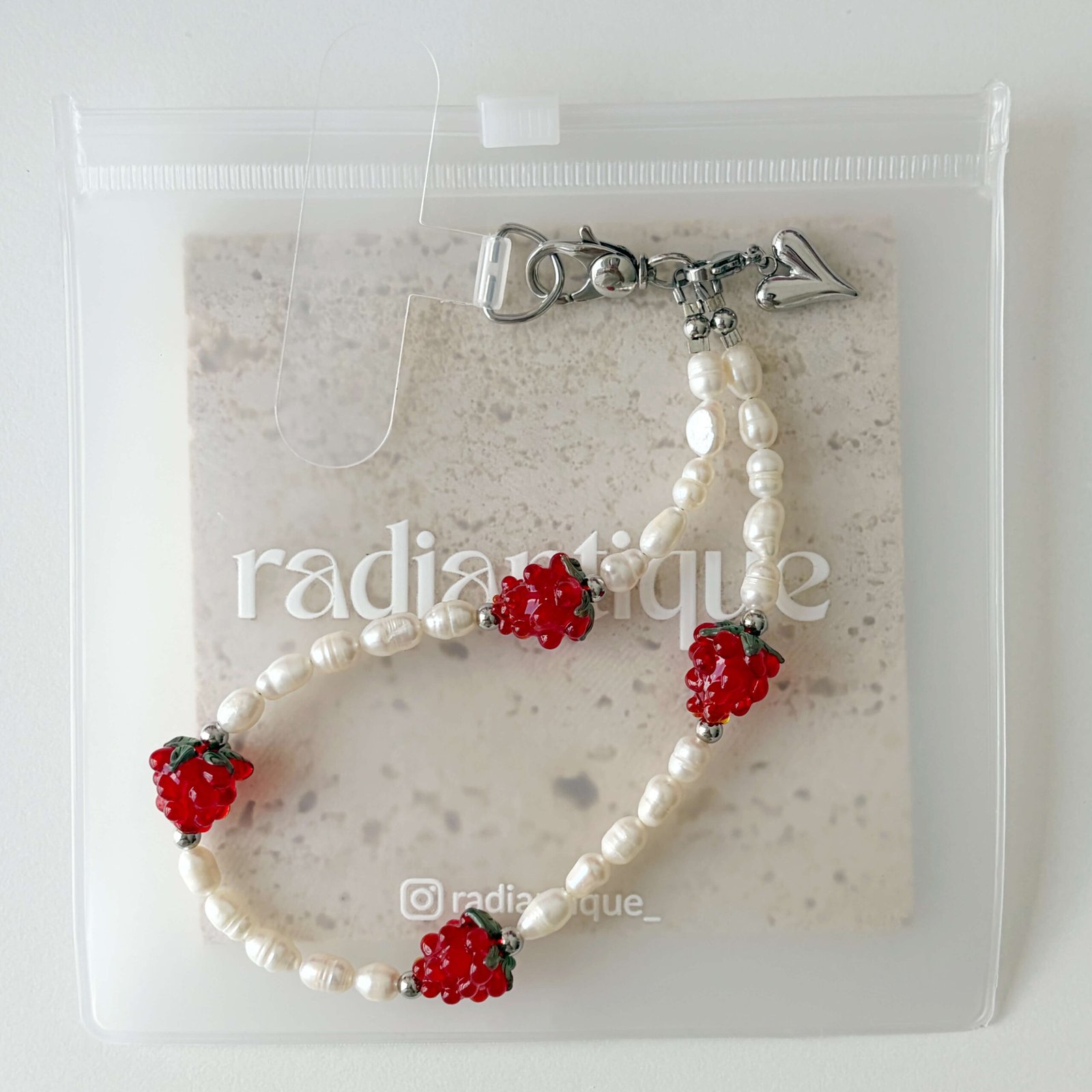 Juicy Pearl phone wristlet strap packed in clear packaging pouch with attachment patch