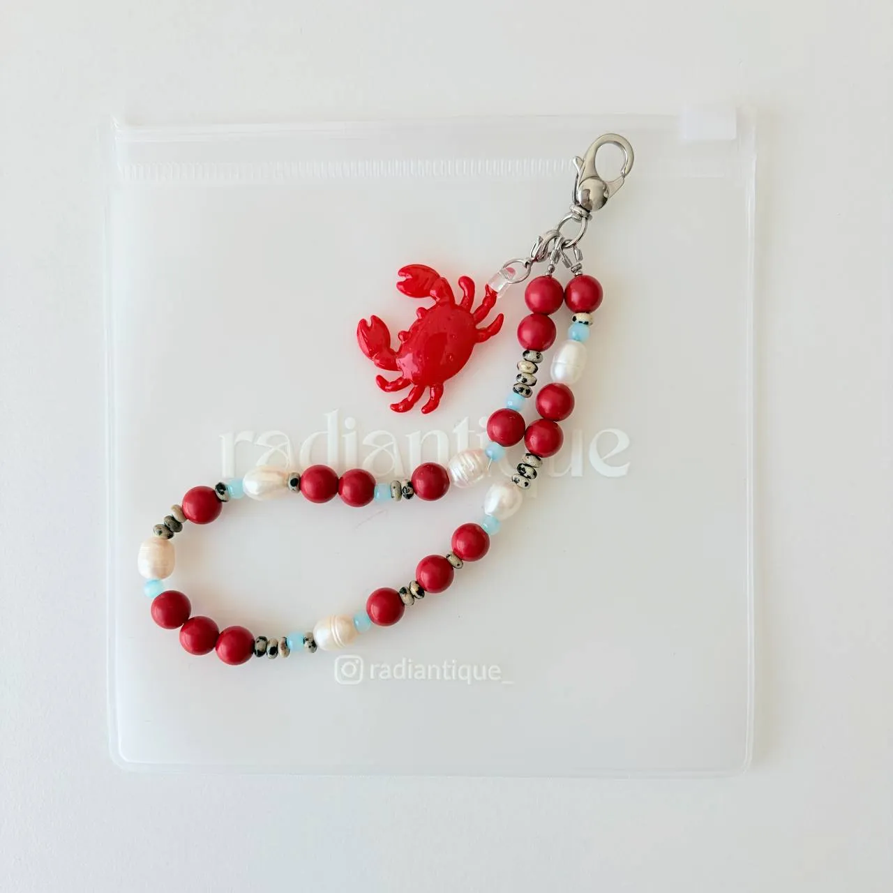 Vertical flat lay view of Coral Crab beaded phone strap