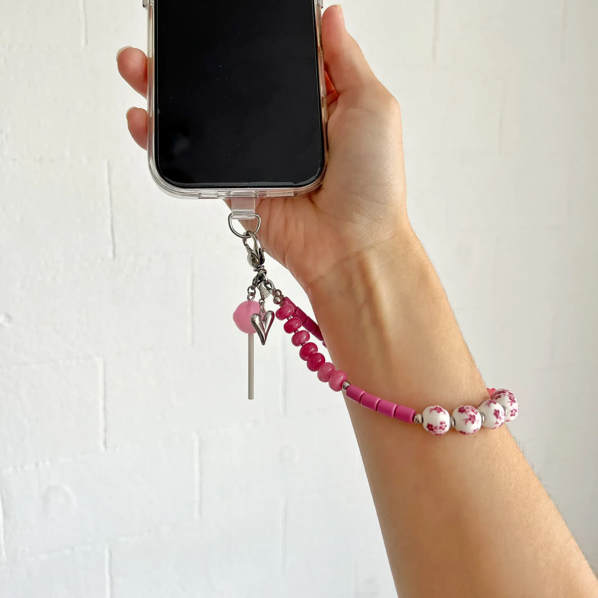 Candy Blossom phone wristlet strap attached to a smartphone case