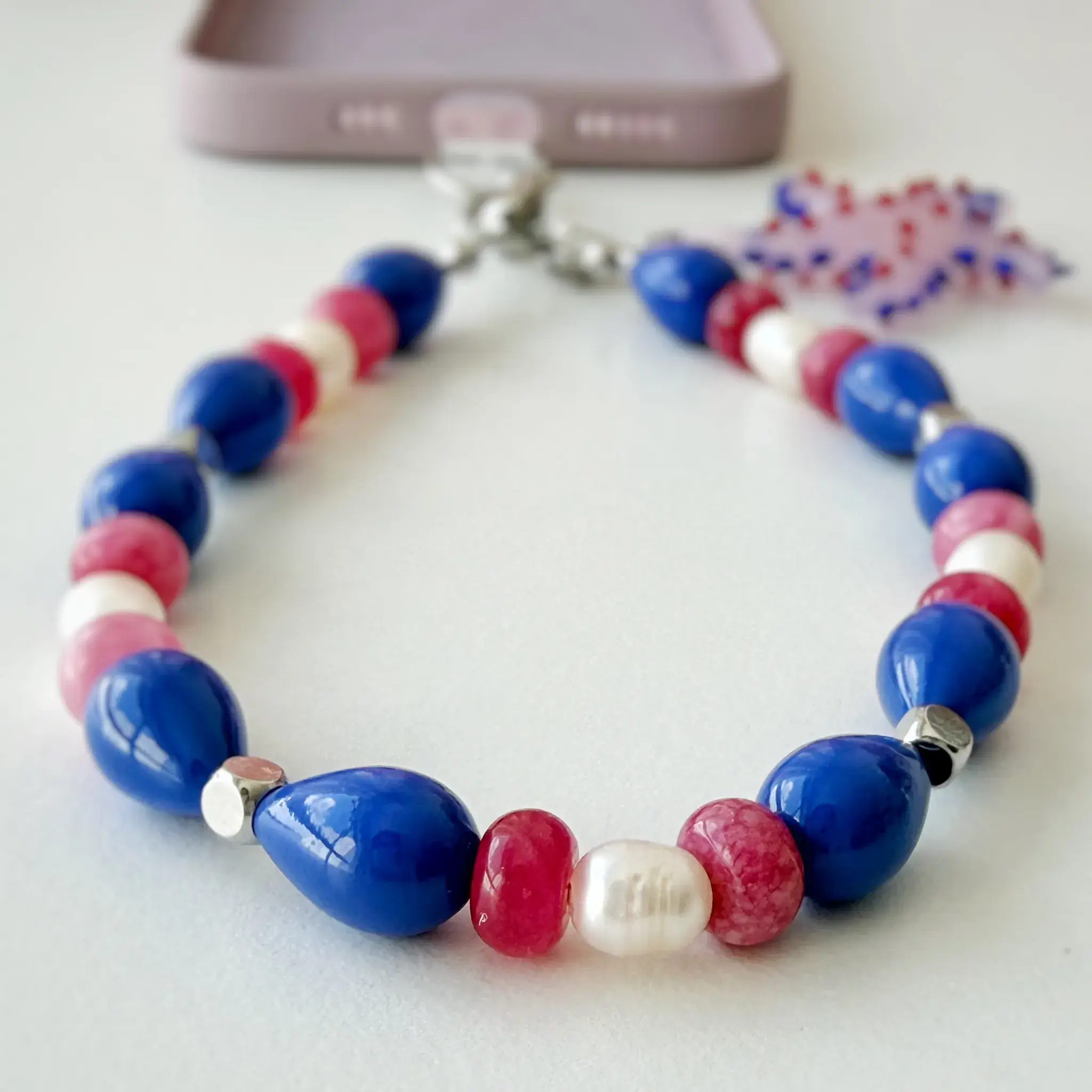 Starfish Bloom beaded phone strap coiled in a circle
