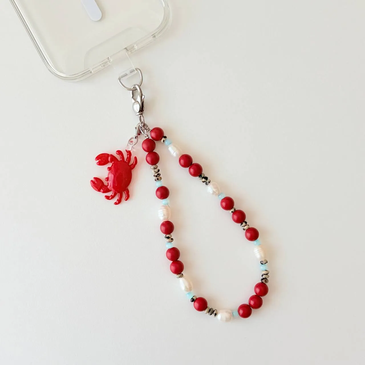 Close-up of red crab pendant and coral beads on Coral Crab wristlet